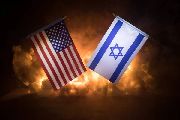 イスラエルと米国の暗い背景に燃える小さな旗 戦争の危機と国家間の政治的紛争の概念 選択的焦点 — ストック写真