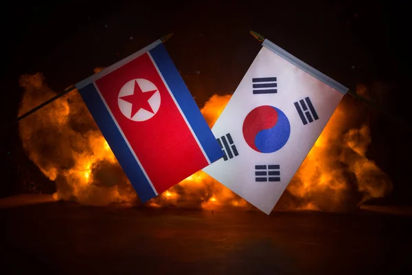 北朝鮮と韓国は暗い背景を燃やして旗を翻す 戦争の危機と国家間の政治的紛争の概念 選択的焦点 — ストック写真