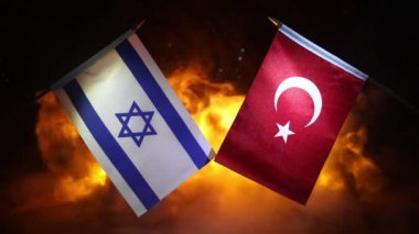 İsrail ve Türkiye 'de yanan koyu arkaplanda küçük bayraklar var. Savaş krizi kavramı ve uluslar arasındaki siyasi çatışmalar. Seçici odak