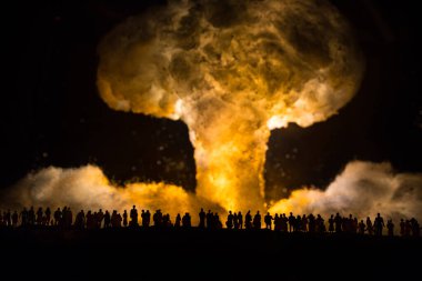 Nükleer savaş konsepti. Nükleer bomba patlaması. Karanlıkta yaratıcı sanat dekorasyonu. İnsanlar atomik patlamanın dev mantar bulutuna bakıyor. Seçici odak