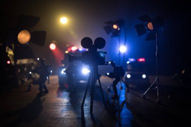 Aksiyon filmi konsepti. Polis arabaları ve minyatür filmler sisli, koyu tonlu arka planda. Polis arabası gece bir arabayı kovalıyor. Suç mahalli kazası. Seçici odak