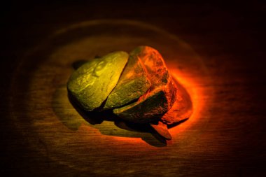 Tahta bir masanın üzerinde kırık taş parçaları. Seçici odak noktasında taşların üzerindeki renkli ışıklar. Kapat.