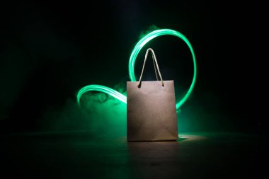 Alışveriş konsepti. Koyu renk masaüstüne saplı kahverengi alışveriş çantası. Seçici odak