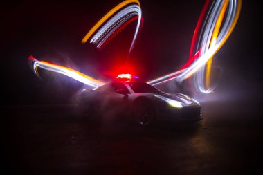 Polis arabası sisli bir arabayı gece takip ediyor. 911 acil durum arabası suç mahalline doğru hızla gidiyor. Yaratıcı dekorasyon. Seçici odak