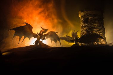 Geceleri ejderhaların bir ortaçağ kalesine saldırdığı fantezi savaş sahnesi. Ejderha ve kahraman askerler arasındaki savaş. Yaratıcı masa dekorasyonu. Seçici odak