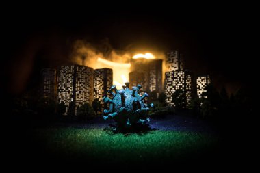 Çizgi film tarzı şehir binaları. Gerçekçi şehir ışıklarla minyatürler inşa ediyor. Geceleri şehirde büyük Corona virüsü minyatürü. Evde kal kendine dikkat et ya da koronavirüs salgını konsepti. Seçici odak.