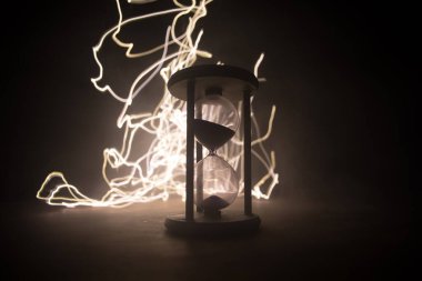 Zaman kavramı. Kum saatinin silueti koyu tonlu arka planda. Kopya alanı ile ilgili soyut bir kavram. Seçici odak