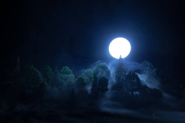 Full moon over the forest at night. Scenic night landscape of country road at night with large moon. Miniature decoration. Selective focus clipart