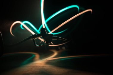 Yaratıcı bir kavram. Koyu tonlu sisli arka planda benzin tabancası minyatürü. Yakıt tabancası yanıyor. Seçici odak