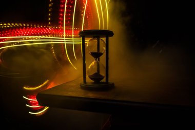 Zaman kavramı. Kum saatinin silueti koyu tonlu arka planda. Kopya alanı ile ilgili soyut bir kavram. Seçici odak