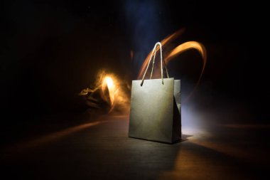 Alışveriş konsepti. Koyu renk masaüstüne saplı kahverengi alışveriş çantası. Seçici odak