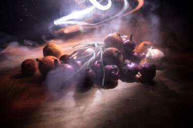 Sebze konsepti. Karanlıkta farklı soğanlar. Seçici odaklanma. Renkli arkaplan.