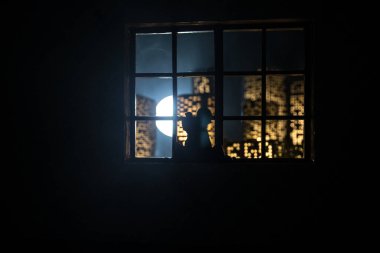 Dollhouse 'un penceresinden gece minyatür bir şehrin güzel manzarası. Pencerede romantik bir çift. El yapımı gerçekçi bebek eviyle sanat masası dekorasyonu. Seçici odak.