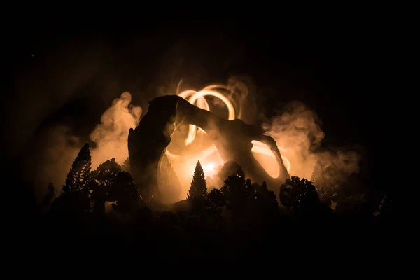 抽象的なシュールなコンセプト 月明かりの下で暗い森の中の巨大な動物の骨 背景に霧と光の夜 選択的焦点 — ストック写真