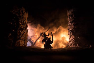 Süvari ve piyadelerle ortaçağ savaş sahnesi. Şekillerin siluetleri ayrı nesneler olarak, karanlık tonlu sisli arka planda ortaçağ şatosuyla savaşan savaşçılar arasında. Seçici odak