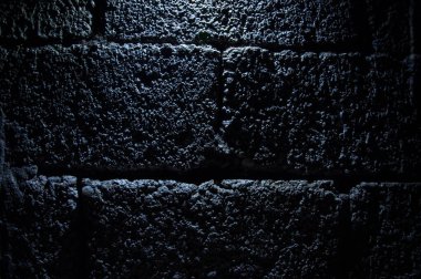 Taş duvar, koyu arka plan ve ışık. Arkaplan için Grunge tarzı duvar