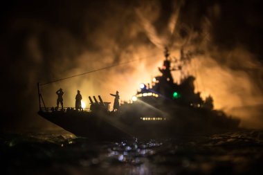 Savaş konsepti. Denizde gece savaşı sahnesi. Dramatik tonlu bulut etkisi. Gece savaş gemisinin silueti. Minyatür yaratıcı masa dekorasyonu. Seçici odak