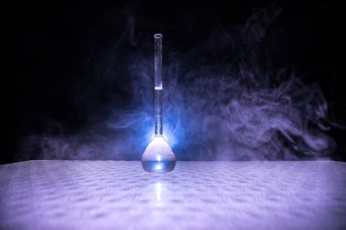 Eczane ve kimya teması. Araştırma laboratuarında çözeltisi olan cam deney şişesi. Bilim ve tıbbi geçmiş. Koyu renk arkaplan üzerinde laboratuvar test tüpleri, bilimsel araştırma ekipmanları konsepti