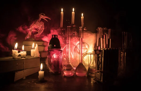 魔法师的办公桌 可怕的万圣节概念 神奇的药水装在木桌上的瓶子里 上面放着书和蜡烛 万圣节静物背景与不同的元素在黑暗色调的雾气背景 有选择的重点 — 图库照片