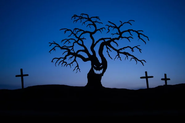 日落时分 墓地上的一些僵尸在走来走去 鬼脸可怕的万圣节树的轮廓 可怕的万圣节概念 有选择的重点 — 图库照片