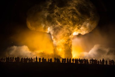 Nükleer savaş konsepti. Nükleer bomba patlaması. Karanlıkta yaratıcı sanat dekorasyonu. İnsanlar atomik patlamanın dev mantar bulutuna bakıyor. Seçici odak