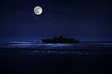 Denizde güzel bir gece sahnesi. Geminin siluetiyle, gece denizin üzerinde dramatik bir ay.