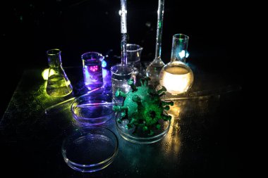 Corona virüsü aşısı konsepti şırınga ve yeşil Corona virüsü romanı minyatür. Koronavirüsle mücadele aşısı. Sis ve arka ışıklandırmalı yaratıcı dekorasyon. Seçici odak