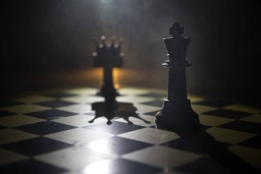 Satranç tahtasında güzel bir taç minyatürü. Satranç masası iş fikirleri, rekabet ve strateji fikirleri konsepti. Duman ve sisli karanlık bir arka planda satranç figürleri. Seçici odak