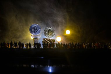 Koyu arka planda Altın Bitcoin. Yeni sanal para. Şifreli para birimi. Seçici odak noktasında Bitcoin 'e bakan kalabalık minyatürü