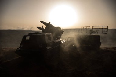 Yaratıcı sanat dekorasyonu. Gün batımında radar antenli mobil hava savunma aracı silueti. Roket fırlatıcı gökyüzüne nişan aldı ve saldırmaya hazır. Seçici odak