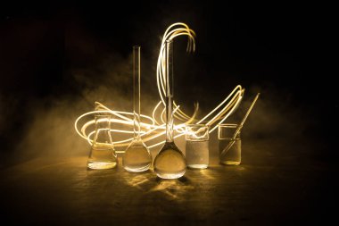 Eczane ve kimya teması. Araştırma laboratuarında çözeltisi olan cam deney şişesi. Bilim ve tıbbi geçmiş. Koyu renk arkaplan üzerinde laboratuvar test tüpleri, bilimsel araştırma ekipmanları konsepti