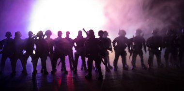 Çevik kuvvet polisi hazır olmak için işaret verdi. Hükümetin güç kavramı. Özel harekat polisi iş başında. Karanlık arka planda ışıklarla tüttürmek. Mavi kırmızı yanıp sönen sirenler. Seçici odak