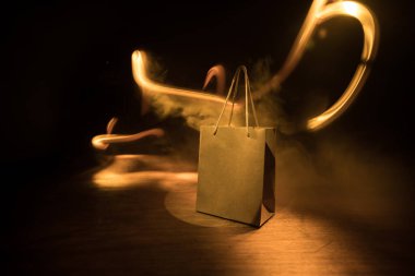 Alışveriş konsepti. Koyu renk masaüstüne saplı kahverengi alışveriş çantası. Seçici odak