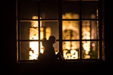 Dollhouse 'un penceresinden gece minyatür bir şehrin güzel manzarası. Pencerede romantik bir çift. El yapımı gerçekçi bebek eviyle sanat masası dekorasyonu. Seçici odak.