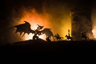 Geceleri ejderhaların bir ortaçağ kalesine saldırdığı fantezi savaş sahnesi. Ejderha ve kahraman askerler arasındaki savaş. Yaratıcı masa dekorasyonu. Seçici odak