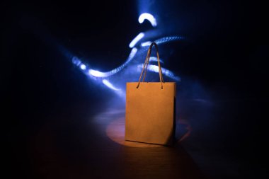 Alışveriş konsepti. Koyu renk masaüstüne saplı kahverengi alışveriş çantası. Seçici odak