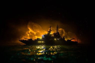 Savaş konsepti. Denizde gece savaşı sahnesi. Dramatik tonlu bulut etkisi. Gece savaş gemisinin silueti. Minyatür yaratıcı masa dekorasyonu. Seçici odak