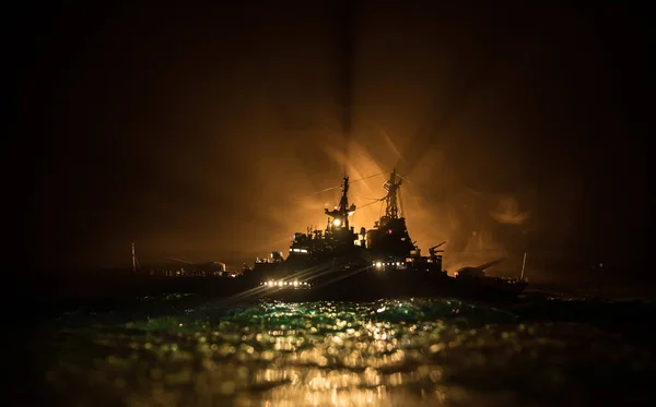 War concept. Night battle scene at sea. Dramatic toned clouds effect. Silhouette of the battle ship in night. Miniature creative table decoration. Selective focus