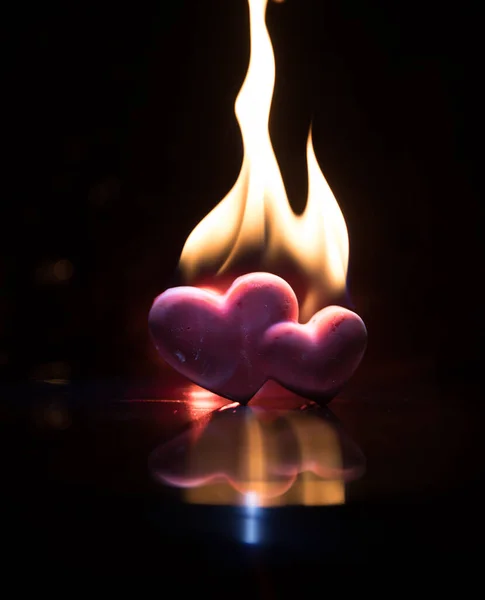 Valentines background. Valentine\'s Day heart on a dark wooden table. Burning hearts. Heart in fire. Dark toned foggy background. Selective focus