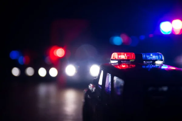 Police cars at night. Police car chasing a car at night with fog background. 911 Emergency response police car speeding to scene of crime. Selective focus