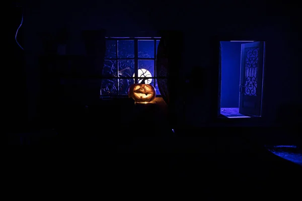 輝くカボチャとハロウィーンのホラーコンセプト 窓のあるリアルな人形の家のリビングルーム 外のゾンビが怖い 選択的焦点 — ストック写真