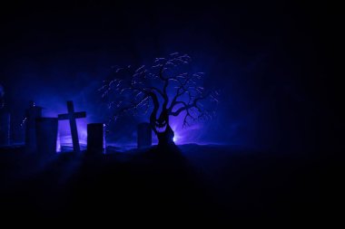 Zombilerin mezarlıktaki ölü ağaç, ay, kilise ve sisli ürkütücü bulutlu gökyüzü, Korku Cadılar Bayramı konsepti. Seçici odak
