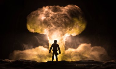 Nükleer savaş konsepti. Nükleer bomba patlaması. Karanlıkta yaratıcı sanat dekorasyonu. Atomik patlamanın dev mantar bulutuna karşı duran asker silueti. Seçici odak
