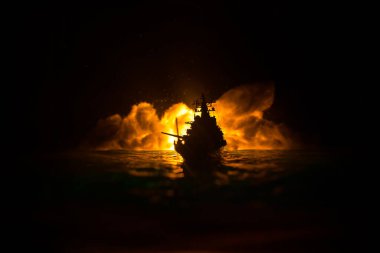 Savaş konsepti. Denizde gece savaşı sahnesi. Dramatik tonlu bulut etkisi. Gece savaş gemisinin silueti. Minyatür yaratıcı masa dekorasyonu. Seçici odak