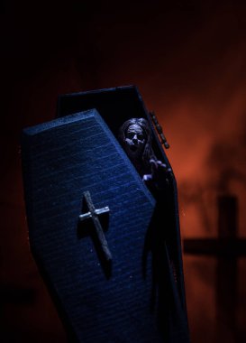 Yaratıcı sanat eserleri. İçinde zombi olan minyatür tahta tabut. Mezarlıktaki korkunç zombi manzarası. Korku Cadılar Bayramı konsepti. Seçici odak