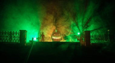 Cadılar Bayramı konsepti Kabak kafalı bir mezarlık. Arka planda sis olan tonlu bir ışık. Seçici odaklanma. Uzun deklanşör.