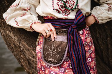 Geleneksel Ukrayna kadın kostümünü nakışlı çanta ve dokuma kemerle kapatın.