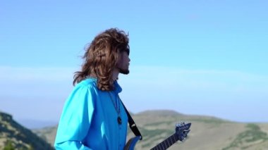 Adam sahada gitar çalıyor.