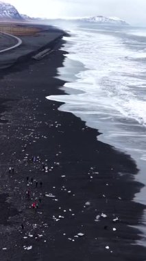 İzlanda kıyısında Diamond Beach Kara Kum ve Buz Parçaları 4K Dikey