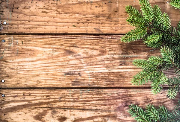 ヴィンテージスタイルの休日の背景として有用な高齢者の木製の板の背景に配置されたトウヒのクリスマスツリー小枝 — ストック写真